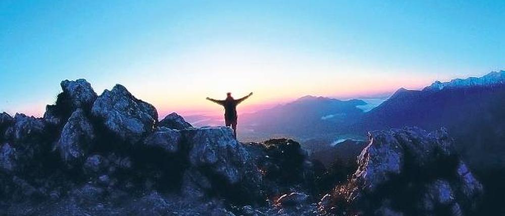 Freiheit am Gipfel in den Ammergauer Alpen frümorgens bei Sonnenaufgang. Foto: dpa