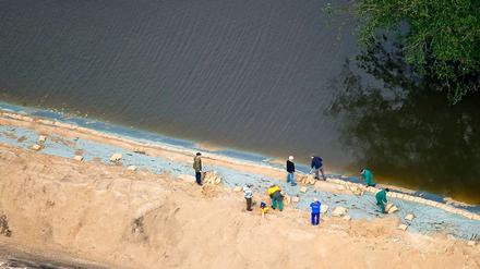 Helfer sichern in Brieskow-Finkenherd einen Deich am Brieskower See. Da der See mit der Oder verbunden ist, ist auch hier das Wasser angestiegen. Der Deich schützt die Zilkendorfer Niederung vor dem Hochwasser.