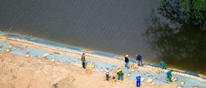 Helfer sichern in Brieskow-Finkenherd einen Deich am Brieskower See. Da der See mit der Oder verbunden ist, ist auch hier das Wasser angestiegen. Der Deich schützt die Zilkendorfer Niederung vor dem Hochwasser.