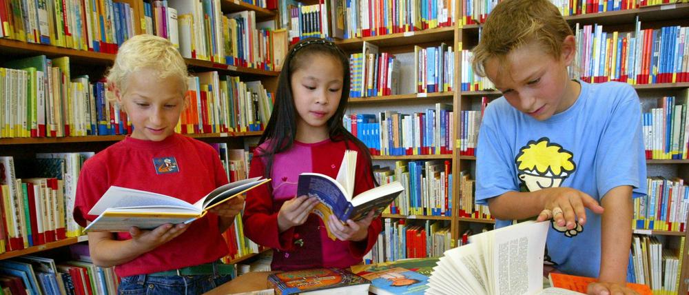 Schüler einer vierten Klasse lesen in einer Grundschul-Bibliothek.