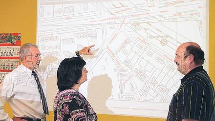 Effektives Tüfteln. Die Logistiker Ralf Ränker, Carola Assmann und Klaus-Peter Gerdum von der BSR (v.l.) planen effiziente Routen für Müllfahrzeuge. Ein an die Wand projizierter Stadtplan, auf dem jedes Grundstück mit Tonnen oder Containern verzeichnet ist, hilft ihnen dabei. 