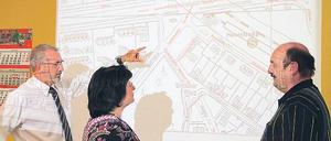Effektives Tüfteln. Die Logistiker Ralf Ränker, Carola Assmann und Klaus-Peter Gerdum von der BSR (v.l.) planen effiziente Routen für Müllfahrzeuge. Ein an die Wand projizierter Stadtplan, auf dem jedes Grundstück mit Tonnen oder Containern verzeichnet ist, hilft ihnen dabei.