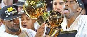 Pokalrunde: Lakers-Spieler Kobe Bryant (rechts) hält die Trophäe für den "Most Valuable Player", sein Teamkollege Derek Fisher reicht ihm den Teampokal dazu.