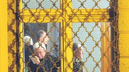 Gibt Fehler zu. Bischof Walter Mixa telefoniert am Dienstag im Bischofspalais in Augsburg. Im Hintergrund sieht man seinen Anwalt Gerhard Decker. Foto: dpa