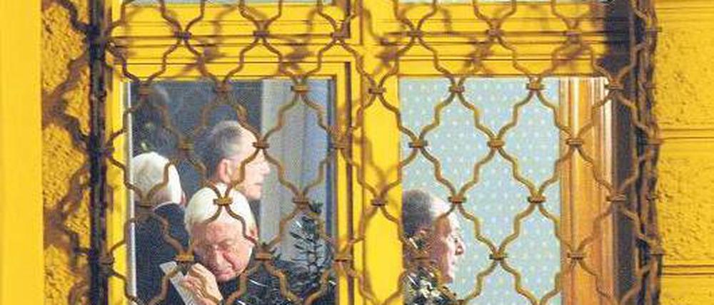 Gibt Fehler zu. Bischof Walter Mixa telefoniert am Dienstag im Bischofspalais in Augsburg. Im Hintergrund sieht man seinen Anwalt Gerhard Decker. Foto: dpa