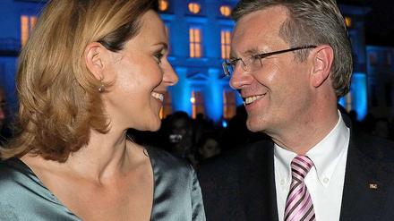 Bundespräsident Christian Wulff und seine Frau Bettina vor dem abendlich beleuchteten Schloss Bellevue.
