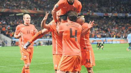 Giovanni van Bronckhorst traf aus fast 40 Metern zum 1:0 (oben rechts), Wesley Sneijder (links obenauf) zum 2:1, und Arjen Robben schaffte sogar ein Kopfballtor. Fotos: AFP (2), dpa