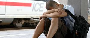 Ein junger Mann wartet auf dem Düsseldorfer Hauptbahnhof auf seinen Zug.