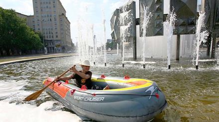 Bei solchen Temperaturen muss man kreativ sein. Dieser Hobby-Kapitän unternimmt eine Schlauchboot-Tour mitten in der Innenstadt.
