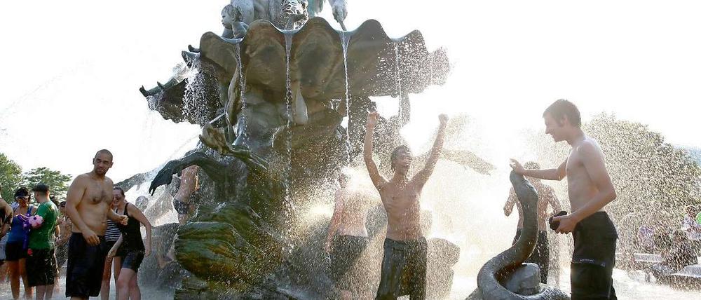 Die Demo kann warten: Protestpause der Anti-Mediaspree-Aktivisten mit Bad im Brunnen. Neptun bleibt entspannt.