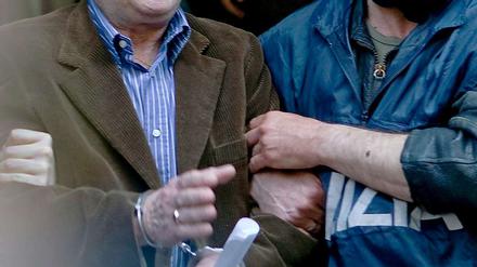 Ein Polizist führt Giovanni Tegano ab, einen der Top-Mafia-Bosse.