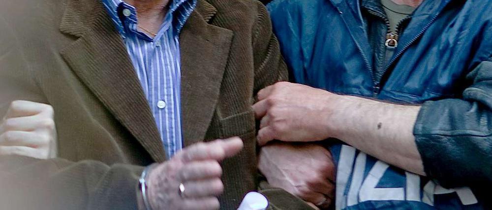 Ein Polizist führt Giovanni Tegano ab, einen der Top-Mafia-Bosse.