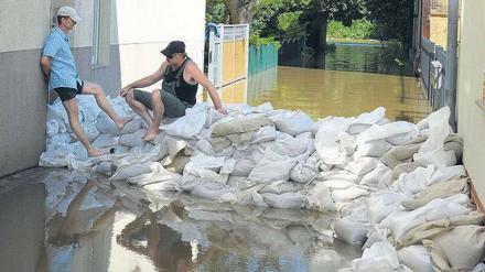 Gestapelte Säcke. In Guben rüstet man sich gegen die Flut. Südlich der Stadt war ein Deich gebrochen; dadurch konnte Wasser abfließen.
