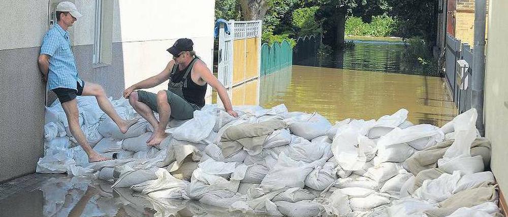 Gestapelte Säcke. In Guben rüstet man sich gegen die Flut. Südlich der Stadt war ein Deich gebrochen; dadurch konnte Wasser abfließen.