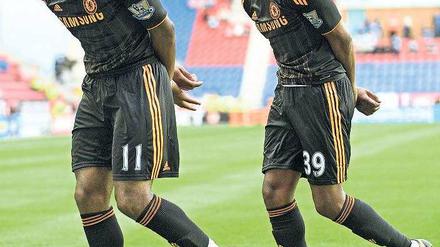 Büßerhaltung? Nein, Jubelchoreografie. Didier Drogba (l.) und Nicolas Anelka feiern den Triumph über Wigan. Foto: AFP