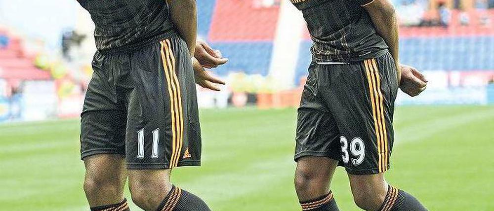 Büßerhaltung? Nein, Jubelchoreografie. Didier Drogba (l.) und Nicolas Anelka feiern den Triumph über Wigan. Foto: AFP
