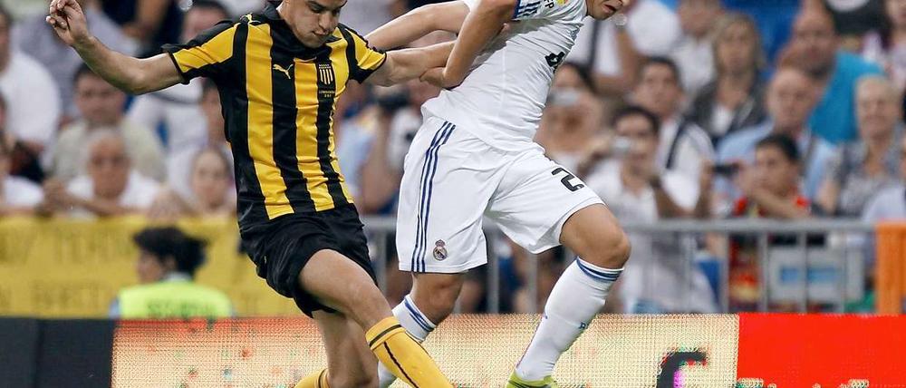 Mesut Özil (r), hier beim Freundschaftsspiel gegen Penarol, ist ein wichtiger Teil bei dem Plan von Real Madrid, Spanischer Meister zu werden.