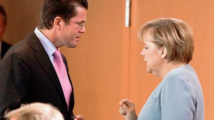 Kurz vor Beginn der Kabinettssitzung tauschen sich Bundeskanzlerin Merkel und Bundesverteidigungsminister zu Guttenberg aus.