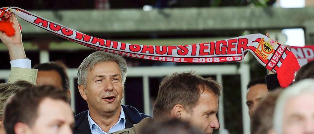 Hoppla, der Regierende, das Hertha-Mitglied, auf einmal mit Union-Schal? Eher nicht. Die Hand am Schal links im Bild gehört Gregor Gysi, der andere Arm hat wohl zu viel Spannweite für Wowereit.