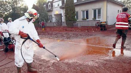 Aufräumarbeiten. Einsatzkräfte spritzen in Kolontar den Schlamm von den Häusern und Straßen. Zuvor war dort roter Industrieschlamm durch die Straßen geströmt, nachdem am Speicherbecken einer benachbarten Bauxitfabrik ein Damm gebrochen war.Foto: Aaron Taylor/dpa