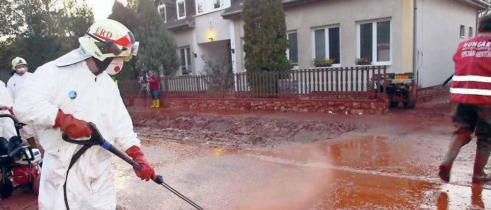Aufräumarbeiten. Einsatzkräfte spritzen in Kolontar den Schlamm von den Häusern und Straßen. Zuvor war dort roter Industrieschlamm durch die Straßen geströmt, nachdem am Speicherbecken einer benachbarten Bauxitfabrik ein Damm gebrochen war.Foto: Aaron Taylor/dpa