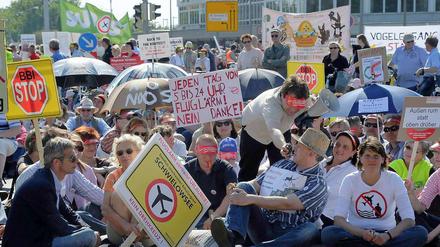 Rund zehn Minuten dauert die Blockade. Die Demonstranten sind gegen die geplanten Flugrouten und die Entstehung eines internationalen Drehkreuzes am BBI. Sie fordern außerdem ein Nachtflugverbot.