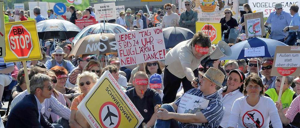 Rund zehn Minuten dauert die Blockade. Die Demonstranten sind gegen die geplanten Flugrouten und die Entstehung eines internationalen Drehkreuzes am BBI. Sie fordern außerdem ein Nachtflugverbot.