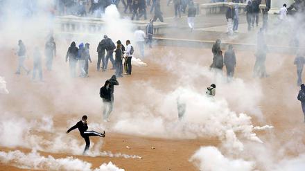 Die Polizei greift bei den Protesten in Frankreich hart durch. Hier versuchen Schüler in Lyon sich vor Tränengas zu schützen.