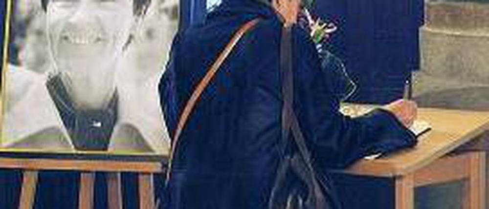 Eine Hamburgerin trägt sich am Freitag in das Kondolenzbuch ein. Foto: dpa