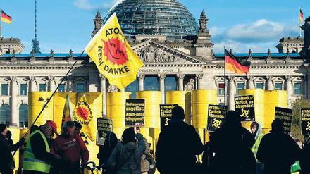 Protest in Schwarz-Gelb. Aus Protest gegen die Atompolitik der Bundesregierung haben Kernkraftgegner am Montag rund 70 Attrappen von Atommüllfässern vor dem Reichstag aufgetürmt. Die Fässer waren tags zuvor in Gorleben auf Lastwagen verladen worden. Foto: dpa