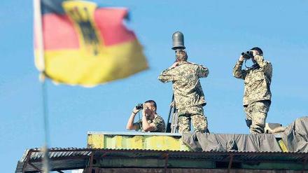 Erkundung. Deutsche Soldaten beobachten im afghanischen Feisabad das Gelände. Foto: Rainer Jensen/dpa