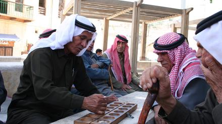 Amjad Nasser beschreibt die Rückkehr aus dem Exil in ein fiktives arabisches Land und die Annäherung an die Welt des Vaters. Rentner beim Mangala-Spiel. 