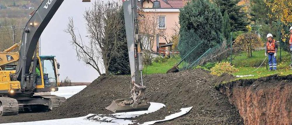 Im Erdkrater werden stabilisierende Geomatten verlegt. Foto: dpa