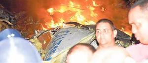 Menschen aus umliegenden Orten helfen bei den Rettungsarbeiten am brennenden Wrack. Foto: AFP PHOTO/HO/ESCAMBRAY NEWSPAPER