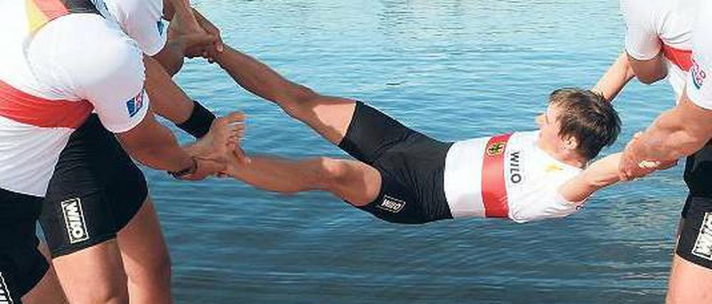 Ritual beim Rudern. Steuermann Sauer wird von seinen Kollegen gefeiert. Foto: dpa