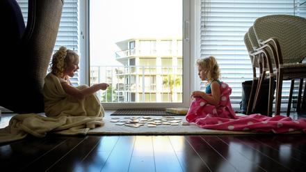 little girls sitting on floor in blankets playing cards in backlight Palm Beach, FL, United States ,model released, Symbolfoto PUBLICATIONxINxGERxSUIxAUTxONLY CRSTWE200123K-137235-01