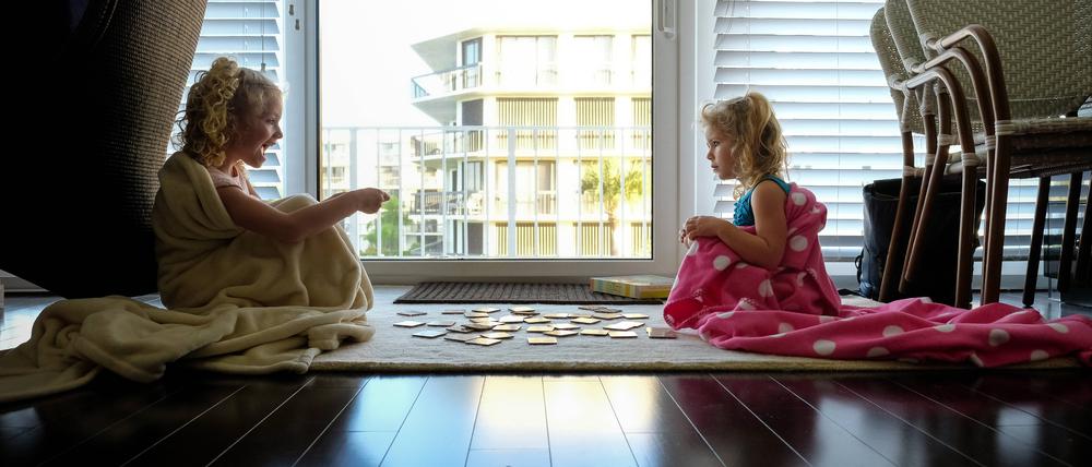 little girls sitting on floor in blankets playing cards in backlight Palm Beach, FL, United States ,model released, Symbolfoto PUBLICATIONxINxGERxSUIxAUTxONLY CRSTWE200123K-137235-01