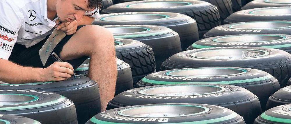Kein heißer Reifen. Ein Mercedes-Mechaniker markiert auf der Formel-1-Strecke von Abu Dhabi Rennreifen. Foto: dpa