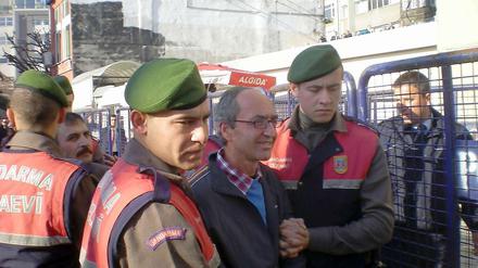 Dogan Akhanli wird am Prozesstag von Polizeibeamten zum Gericht in Istanbul gebracht. 
