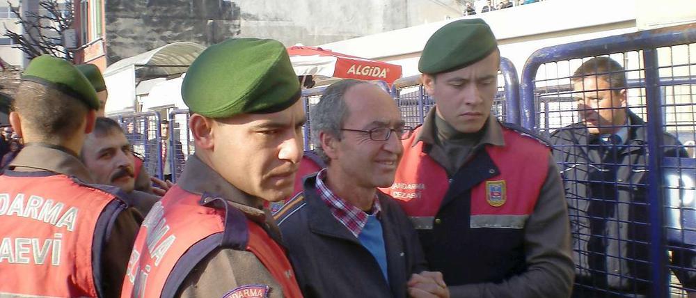 Dogan Akhanli wird am Prozesstag von Polizeibeamten zum Gericht in Istanbul gebracht. 