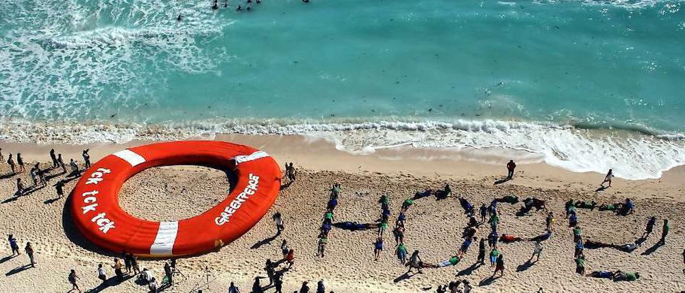 Zuversichtlich: Eine Aktion von Klimaschützern am Strand con Cancún.
