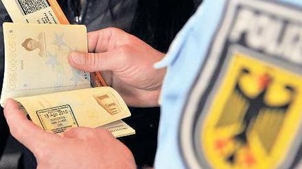 Bundespolizei im Dienst. Beamte kontrollieren die Dokumente ankommender Reisender am Flughafen in Frankfurt am Main. Demnächst soll aus Bundespolizei und Bundeskriminalamt eine einzige Behörde werden.