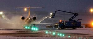 Flughafen bei Nacht. Enteisungsmannschaften arbeiten ohne Unterbrechung auf dem Rollfeld.
