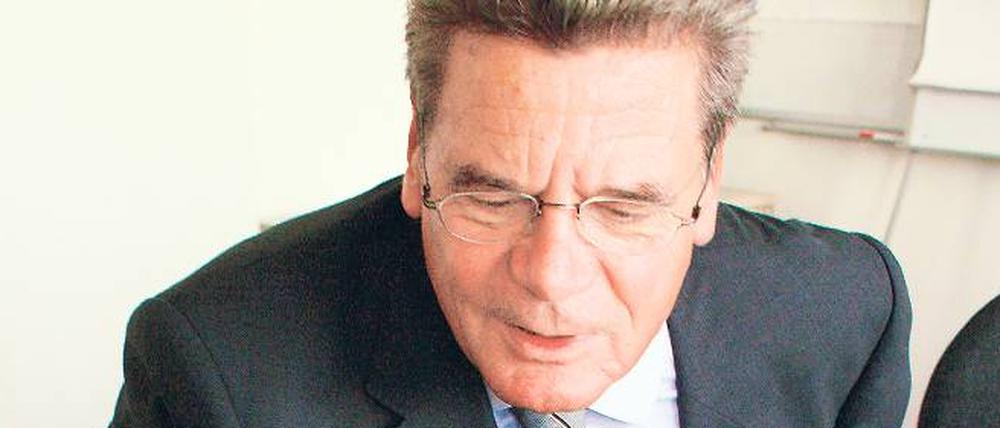 Auf Spurensuche. Joachim Gauck schaut sich bei einem Besuch beim Tagesspiegel Fotos aus der Wendezeit an. Er wünscht sich mehr Einmischung der Bürger. 