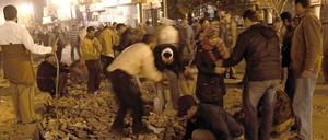 Demonstranten bewaffnen sich mit Pflastersteinen. Es sind auch Schüsse aus schweren Maschinengewehren zu hören.