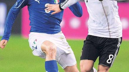 Hart am Ball. Mesut Özil (rechts) bereitete die deutsche Führung vor, musste dann aber den Ausgleich der Italiener um Giorgio Chiellini hinnehmen. ]Foto: AFP