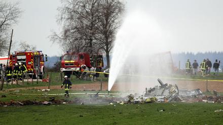 Feuerwehrleute löschen die Trümmer des abgestürzten US-amerikanischen Militärflugzeuges.