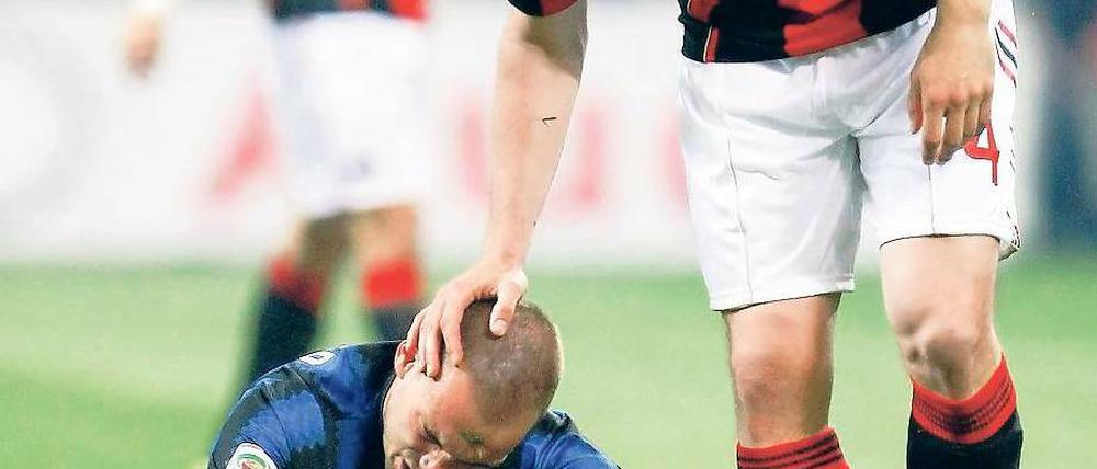 Trost vom Treter. Milans Mark van Bommel versucht, seinen Landsmann Wesley Sneijder aufzumuntern. Foto: Reuters