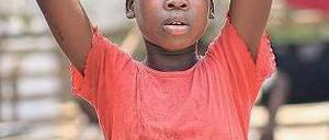 Opfer des Krieges. Ein zwölfjähriges Flüchtlingskind trägt in einem Lager an der Grenze zwischen der Elfenbeinküste und Liberia einen Eimer mit Wasser.