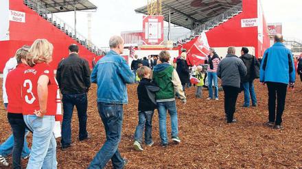 Drei-Spiele-Heimat. Über zerkleinerte Baumrinde schreiten Düsseldorfs Fans zu den improvisierten Tribünen. Im Hintergrund ist das eigentliche Stadion zu erkennen. Foto: dpa